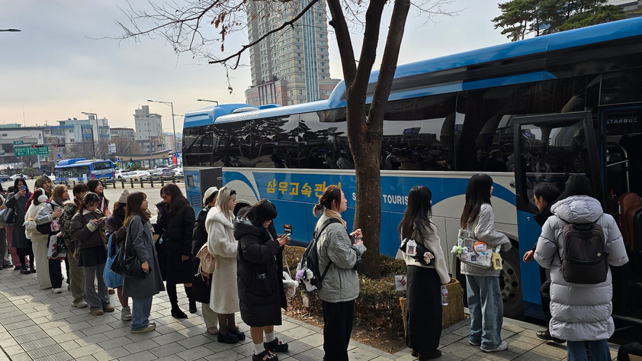 QR코드가 포함된 영문 E티켓을 보여주며 셔틀에 탑승하는 외국인 관객
