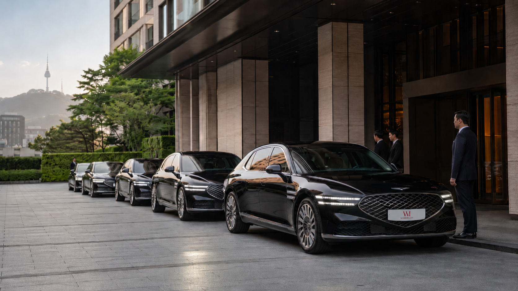 A formation of Genesis G90 sedans staged outside a Hannam-dong hotel, ready for the morning movement of an inbound brand operation in Seoul.