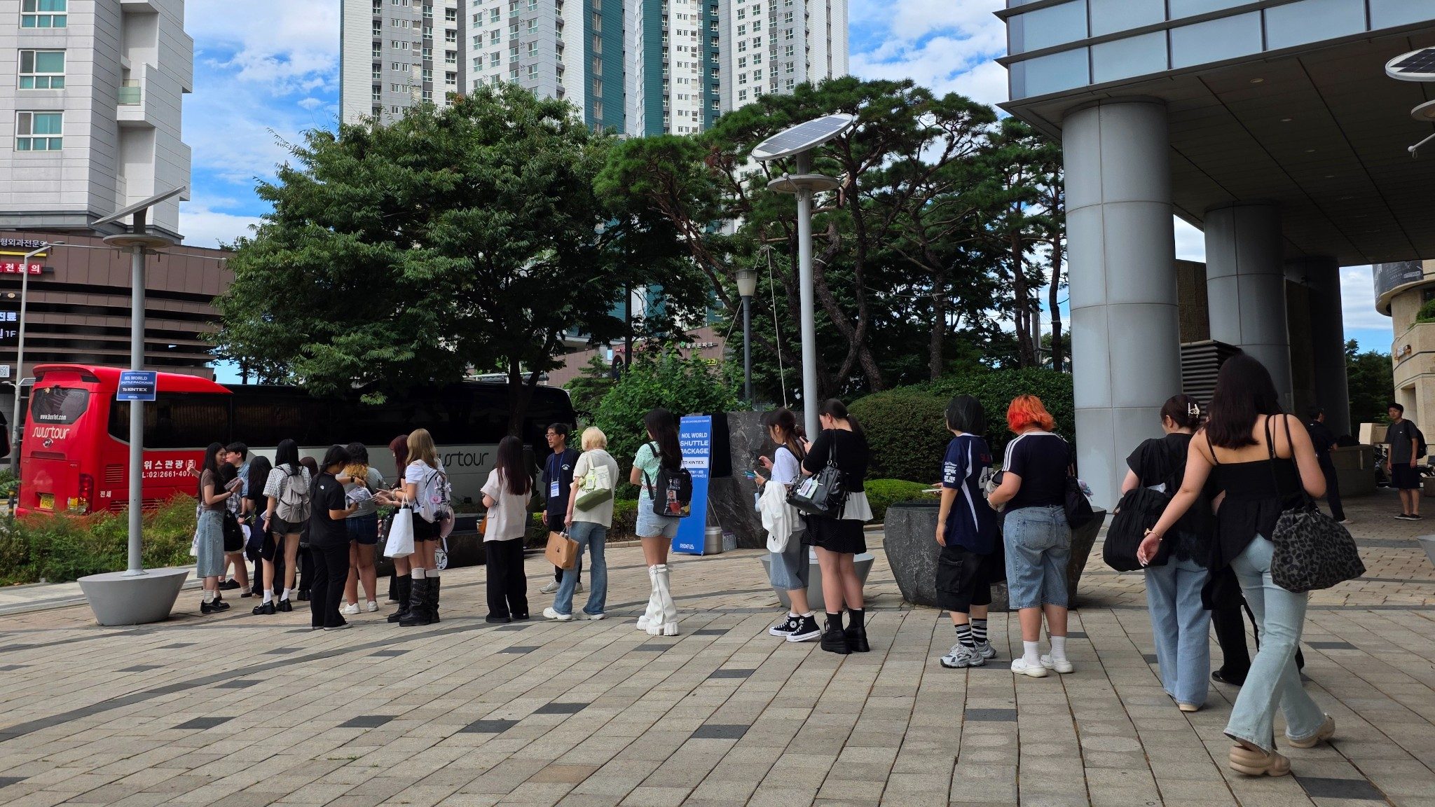 GroundK staff directing passengers at the shuttle boarding point outside Hapjeong Station Exit 9