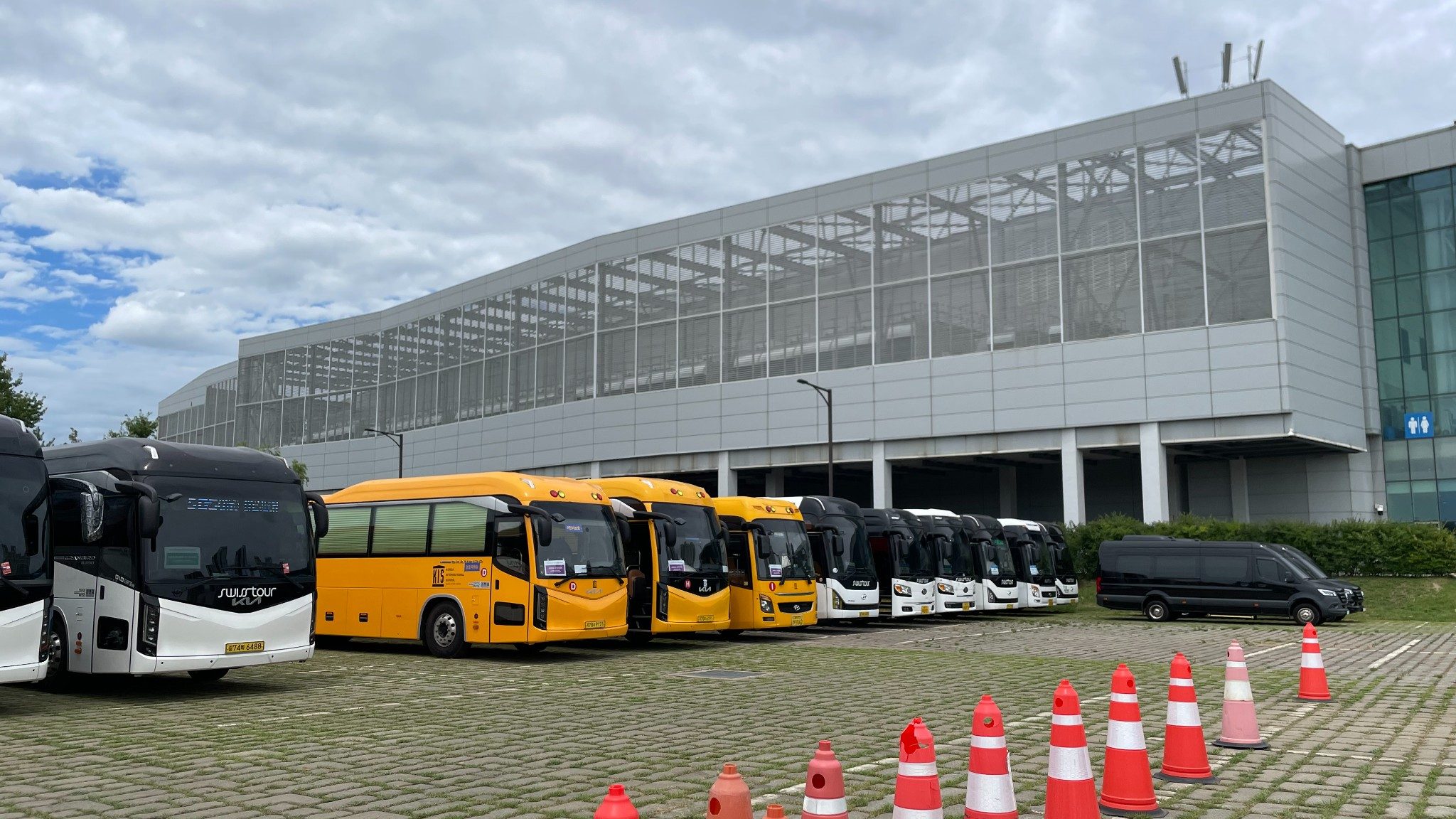 45-seat coaches lined up at the KINTEX Hall 2 T4 temporary car park, with route signage displayed at each boarding position